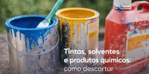 Balde azul com tinta e pincel verde, balde amarelo e recipiente vermelho ao ar livre