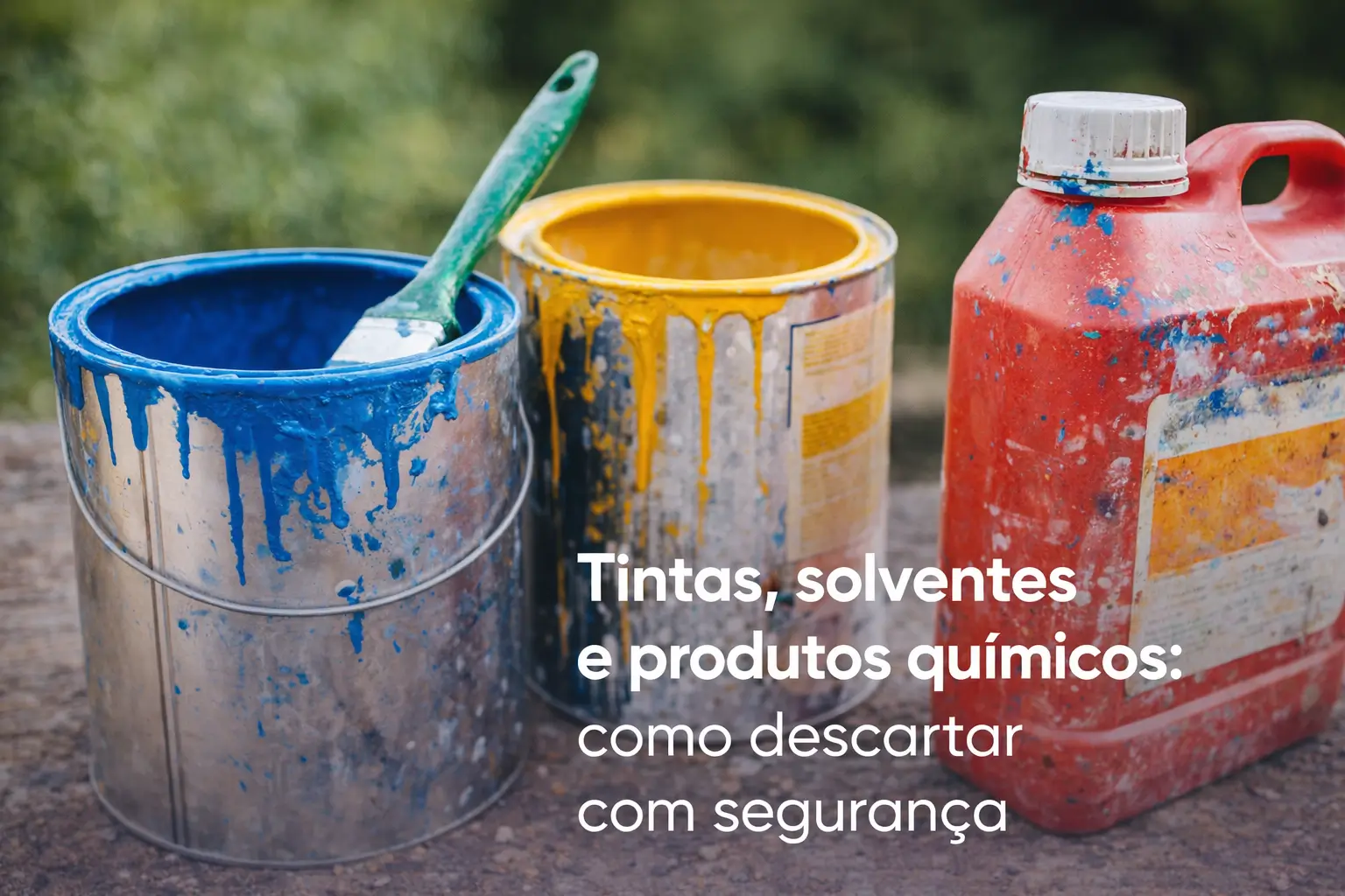 Balde azul com tinta e pincel verde, balde amarelo e recipiente vermelho ao ar livre